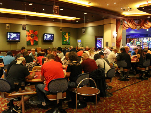 Groups of card players in a poker tournament at the casino.